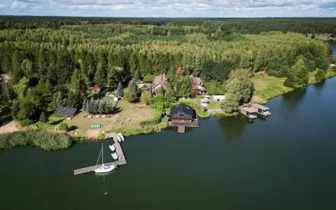Widok z lotu ptaka na jezioro, las i domki nad wodą.