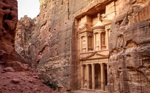 The Treasury in Petra, Jordan, emerges from a narrow canyon. It's a long journey, but how far is Petra from Amman? This ancient city is worth the trip.