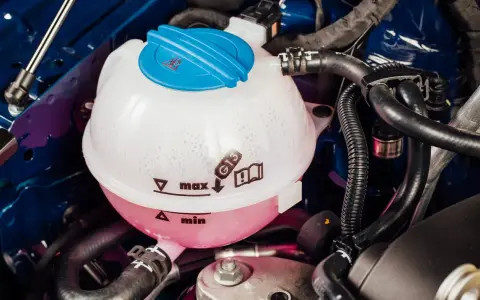 Kühlmittelbehälter eines VW Passat B8. Blasenbildung deutet auf mögliche Probleme mit der Wasserpumpe hin.