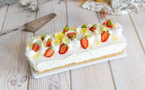 Cheesecake citron facile rapide, garni de fraises fraîches et de zestes de citron. Un délice crémeux et acidulé.