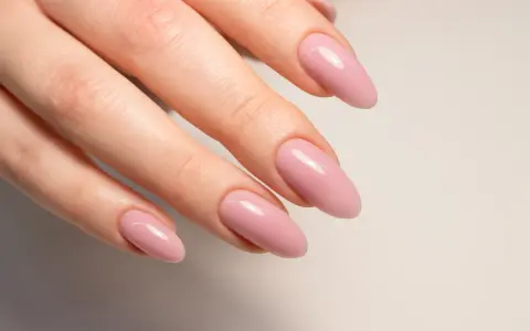 Mano con unghie naturali rosa pallido, forma a mandorla.