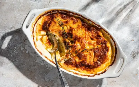 Ein goldbraun gebackener Gratin Dauphinois im ovalen Auflauf, bereit zum Servieren. Dieses Gratin Dauphinois Rezept ist ein Klassiker.