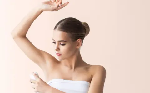 Donna applica deodorante sotto l'ascella. Si discute se l'aluminum chlorohydrate fa male.