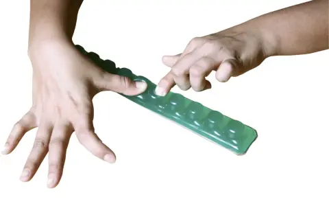 Händer som trycker på en grön gelremsa med bubblor, en rolig finger fidget.