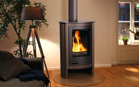 Stufa moderna con fiamme vive, pronta per la pulizia. Accanto, un divano accogliente e una lampada di design.