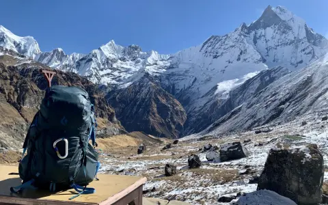 Plecak gotowy na trekking w Himalajach na własną rękę. Majestatyczne, ośnieżone szczyty w tle zapraszają do przygody.
