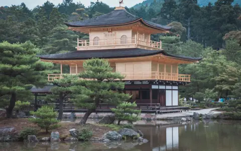 Złoty Pawilon w Kioto, Japonia. Wspaniałe miejsce, które warto zobaczyć, otoczone zielenią i odbijające się w stawie.