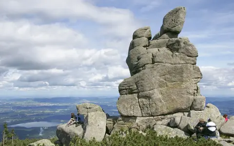 Skalny słonecznik w Karpaczu, z turystami odpoczywającymi na tle malowniczego krajobrazu.