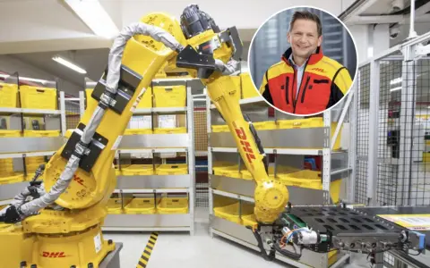 Zautomatyzowany magazyn DHL, duża giełda niemiecka, z robotem i uśmiechniętym menedżerem.
