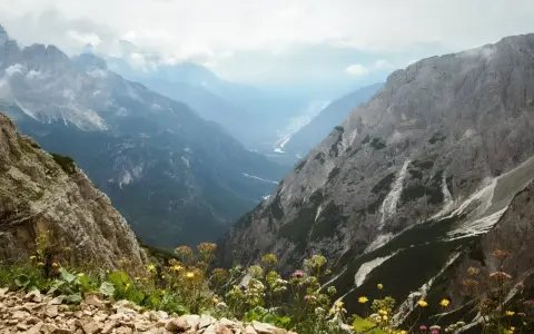 Widok z górskiej ścieżki na dolinę. Czy dolomity to Alpy? Tak, te skaliste szczyty i zielone doliny wyglądają jak Alpy.