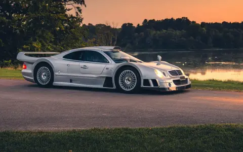 Silberner Mercedes CLK GTR am Seeufer bei Sonnenuntergang. Ein Blick auf dieses seltene Sammlerstück, das den Begriff "Mercedes CLK GTR Preis" neu definiert.