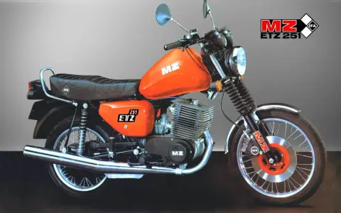 Pomarańczowy motocykl MZ ETZ 251 z widocznymi danymi technicznymi. Klasyk z NRD, gotowy do jazdy.