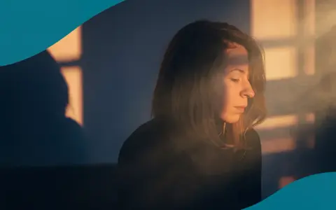 En kvinna med slutna ögon i varmt ljus, kanske en stund för att lindra PMS.
