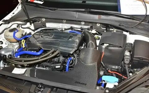 Silnik samochodowy 1.8 TSI z elementami z włókna węglowego i niebieskimi przewodami.