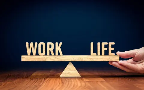 Waga symbolizująca work life balance co to jest. Drewniane litery "WORK" i "LIFE" na szali.