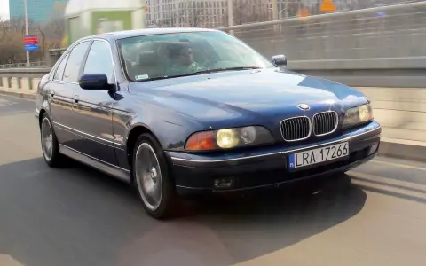 Niebieskie BMW serii 5 (E39) z silnikiem m52b20 jedzie po moście.