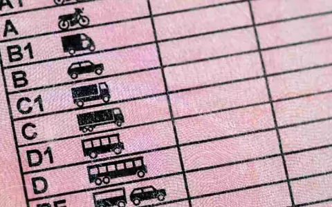 Detalle de un permiso de conducir con iconos de vehículos, incluyendo motocicletas, coches y camiones. Muestra las diferentes categorías de permisos de moto y otros vehículos.