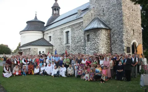 Wielka grupa ludzi, w tym dzieci i duchowni, pozuje przed zabytkowym kościołem parafii Skarżysko.