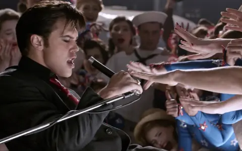 Elvis Presley, der Film: Ein junger Elvis singt mit Leidenschaft ins Mikrofon, umringt von jubelnden Fans.
