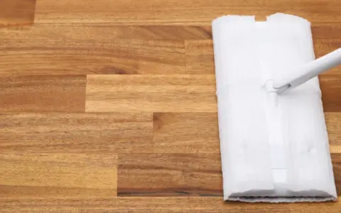 Un paño blanco se desliza sobre un suelo de madera, listo para limpiar.