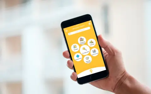 Mano sujetando un smartphone con una app de entregas. Muestra opciones como "Comida", "Supermercado" y "Parafarmacia". Así funciona "just eat".