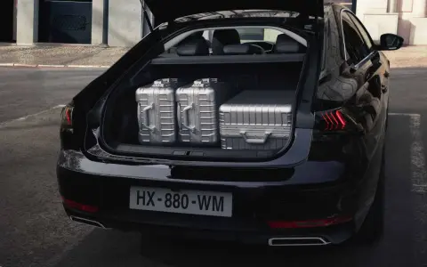 Maletero del Peugeot 508 SW listo para un viaje, con tres maletas plateadas de gran capacidad.