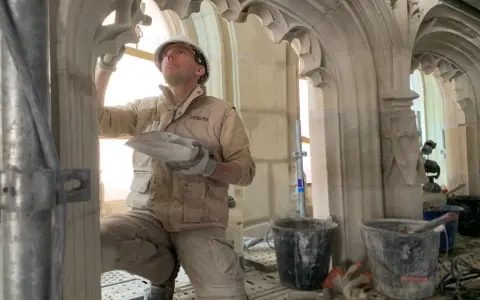 Un maçon restaure la voûte de la cathédrale de Nantes, un chantier qui suit l'incendie.