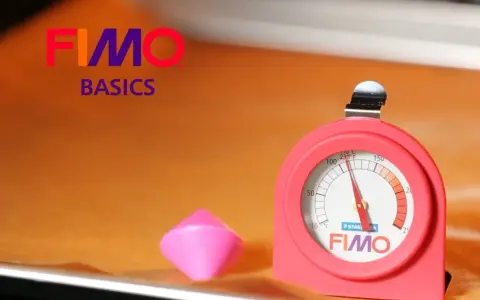 Termometro per forno per fimo, accanto a un pezzo di pasta modellabile rosa.