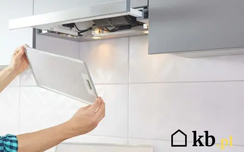 Mężczyzna wyjmuje metalowy filtr z okapu. To ważny element, który wpływa na to, na jakiej wysokości okap będzie skutecznie działał.
