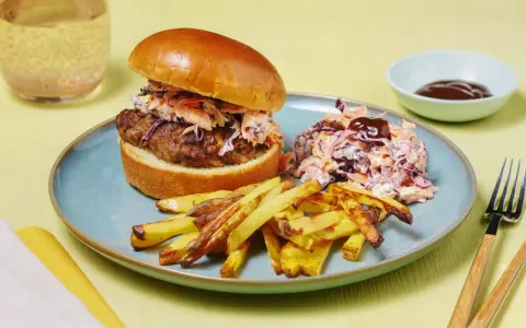 En saftig hamburgare med krispig coleslaw och pommes frites. Ett perfekt hamburgare recept för en härlig måltid.