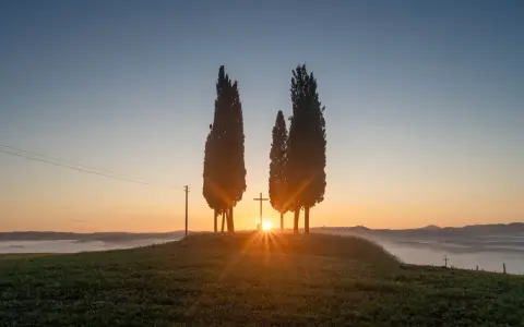 Alba in Toscana con cipressi e croce, un'immagine HDR a.