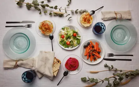 Un repas végétarien servi à l'assiette : houmous, salade, carottes et betterave. Une belle définition du service à l'assiette.