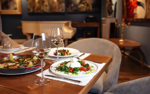 Un dîner romantique dans un restaurant sur Tours. Paella et burrata fraîchement préparées, accompagnées de vin blanc.