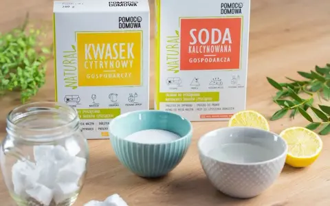 Naturalne środki czystości: kwasek cytrynowy do zmywarki i soda kalcynowana. Obok słoik z kostkami, miseczki z proszkiem i wodą, cytryny.