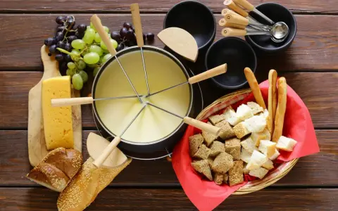 En härlig ostfondue, en klassisk schweizisk matupplevelse, med bröd, vindruvor och ost.