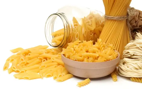 Różne rodzaje makaronu: penne, fusilli w miseczce, spaghetti nr 5 i spaghettini.