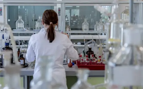Naukowczyni w białym fartuchu pracuje w laboratorium chemicznym, przygotowując eksperyment. To kluczowy etap, jak otworzyć laboratorium chemiczne.