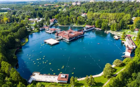 Termalne jezioro z pływającymi budynkami i ludźmi kąpiącymi się w wodzie. To jedno z najpiękniejszych miejsc nad Balatonem.