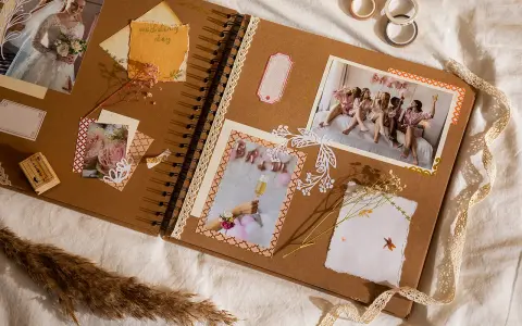 Otwarta księga wspomnień, gdzie co to jest scrapbooking widać na zdjęciach z wesela, ozdobiona wstążkami i suszonymi kwiatami.