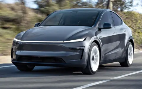 Szary Tesla Model Y w ruchu. Sprawdź aktualną tesla model y cena i możliwości tego elektrycznego SUV-a.