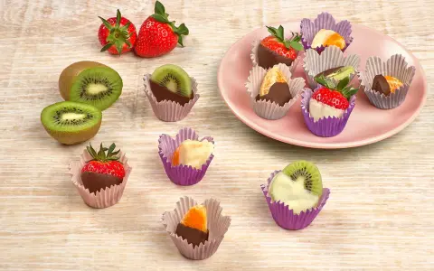 Fruktbitar doppade i choklad och vit choklad, serverade i färgglada cupcake formar. Jordgubbar, kiwi och apelsin.