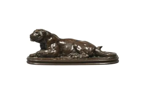 Sculpture en bronze d'un lion couché, œuvre du sculpteur Barye. La signature est discrète.