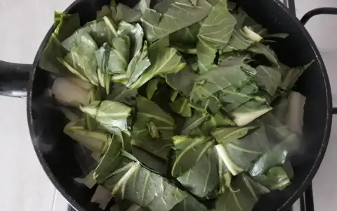 Verdure a coste in padella, che rilasciano vapore mentre cuociono.