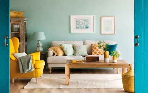 Un sillón amarillo vibrante y cojines con estampados alegres muestran los **colores que combinan con mostaza** en esta sala de estar acogedora.