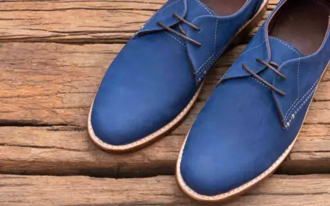 Un paio di eleganti scarpe blu con lacci marroni, perfette per completare un abito blu.
