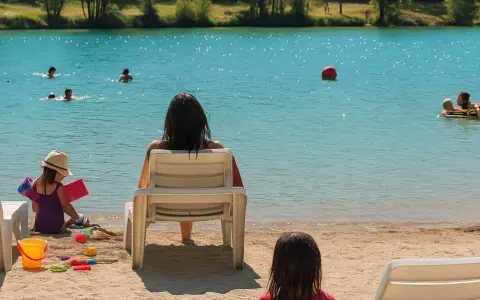 Journée baignade à L'Isle-sur-la-Sorgue. Des enfants jouent dans l'eau turquoise, d'autres sur le sable. Une mère surveille, profitant du soleil.