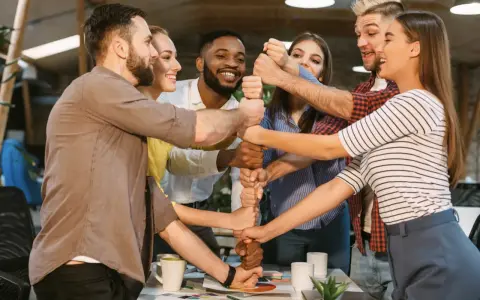 Une équipe soudée, poings serrés, symbolisant l'unité et la collaboration. Une belle idée séminaire pour renforcer la cohésion.