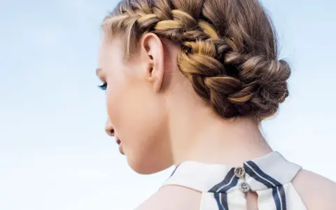 Peinados con trenzas: una mujer con un recogido trenzado elegante, ideal para un día soleado.
