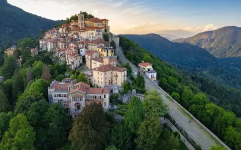 Borgo pittoresco su un colle, ideale per scoprire cose da fare a Varese. Case colorate, un campanile e sentieri panoramici tra il verde.