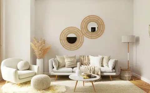 Przytulny, mały pokój inspiracje: jasna sofa, fotele, okrągłe lustra z wikliny, suszone trawy, dywan i lampa.